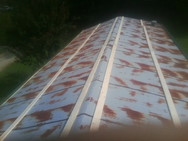 Rusted metal roof panels with new wood purlins before replacement — Storm Damage Roof Repair in Texhoma by Roofing Brothers