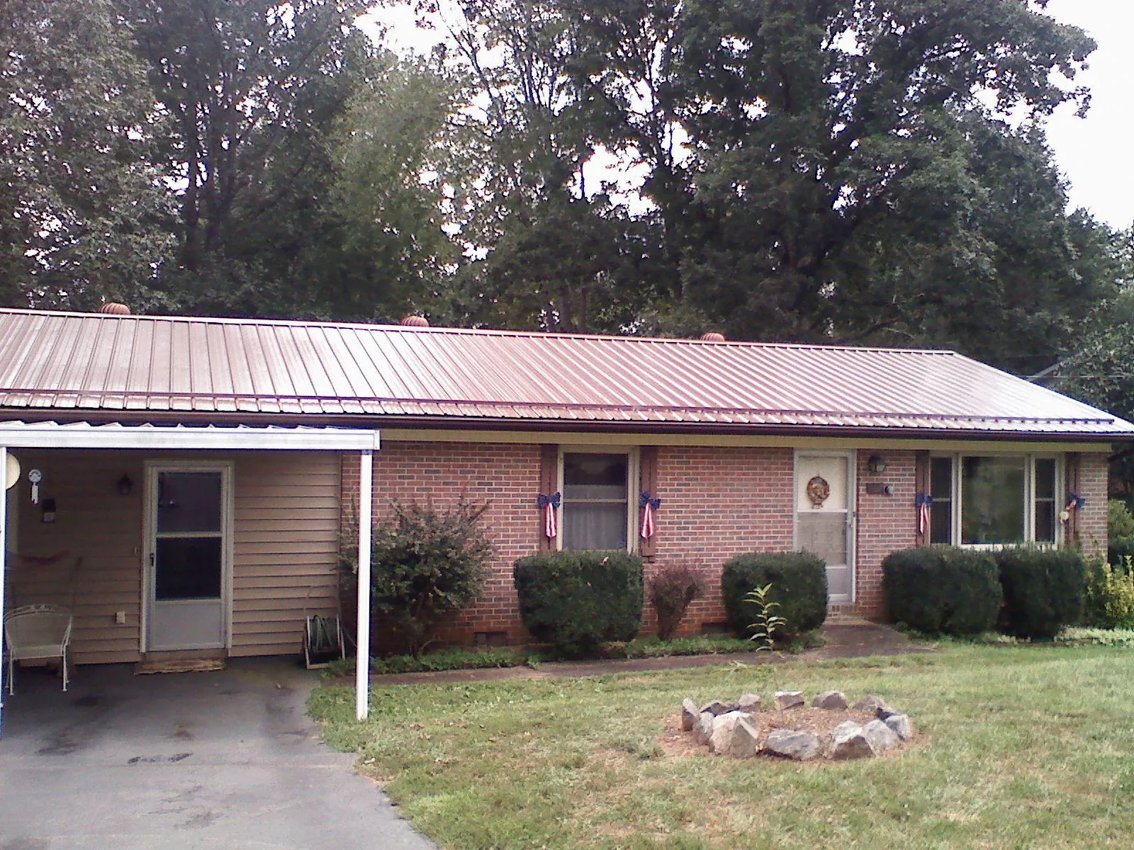 Bronze metal roof and carport on a brick ranch home — Roof Repair work by our crew in Texhoma
