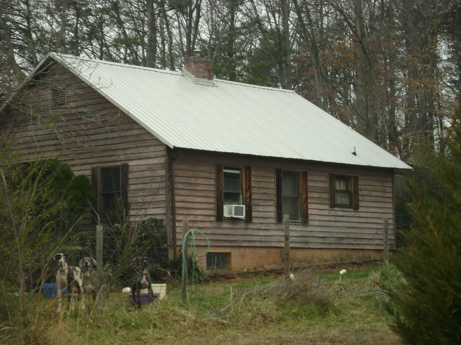 White metal roof on an old wood sided farmhouse, from a Metal Roof Installation job in Texhoma